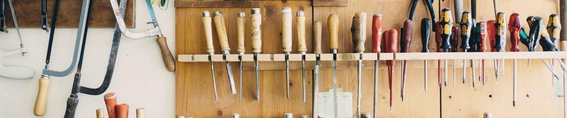 Eine Werkbank mit vielen Werkzeugen an der Wand un einer aufgeräumten Arbeitsfläche