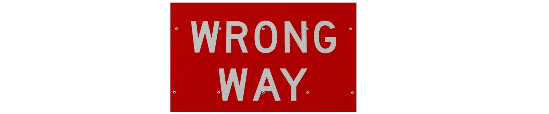 Ein Straßenschild auf dem wrong way steht in rot mit weißer Schrift.